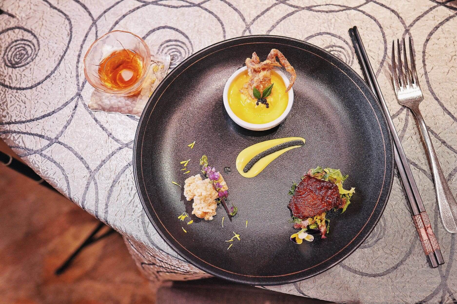 由煙燻鯧魚、蟹茶碗蒸及爆玉米花組成精緻菜餚。