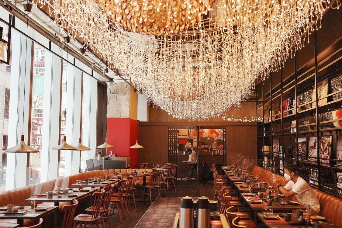 餐廳以日本大街小巷嘅居酒屋為室內設計概念。垂掛嘅吊燈，洋溢街頭氣息。